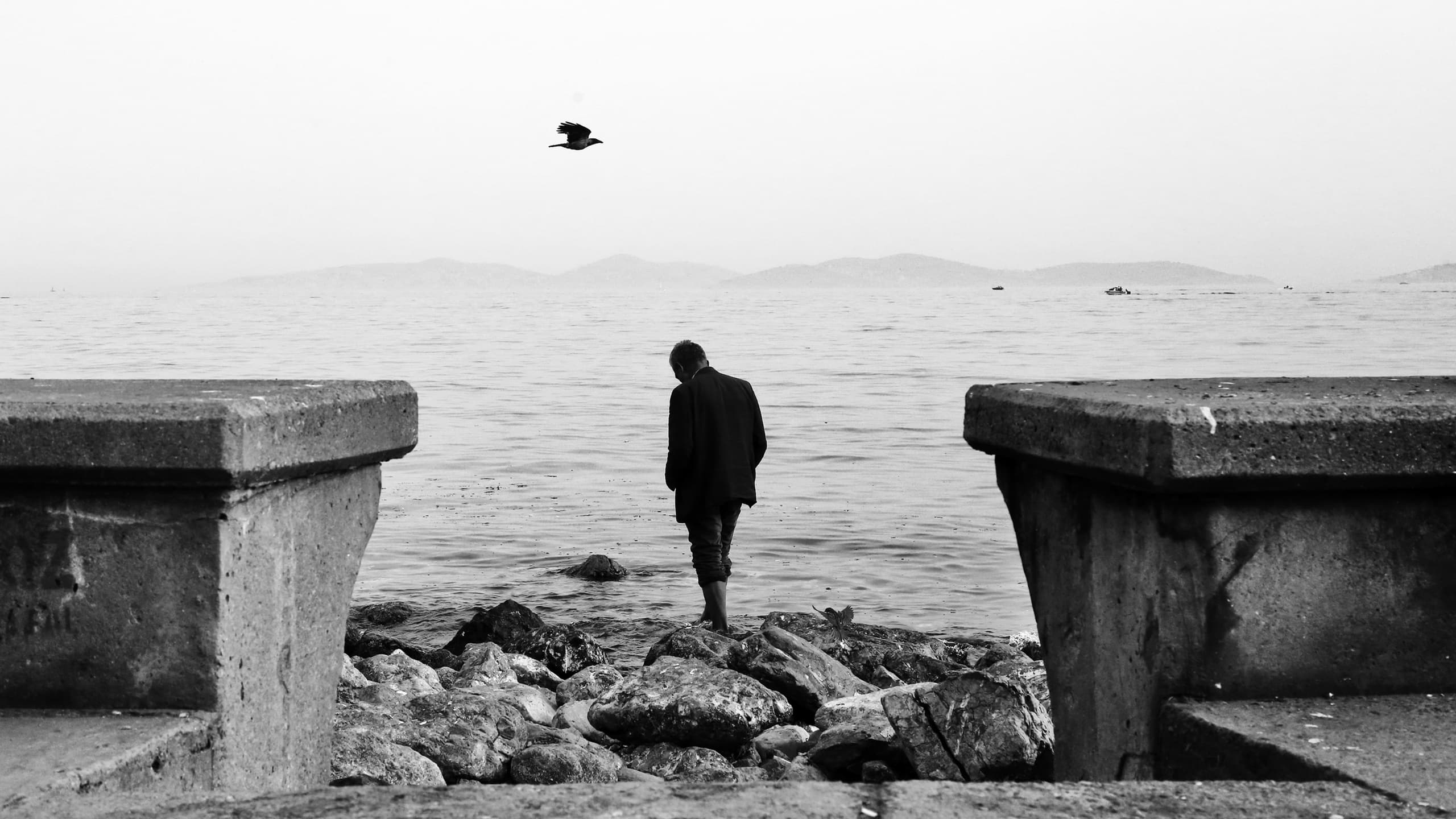 Man standing near edge of lake