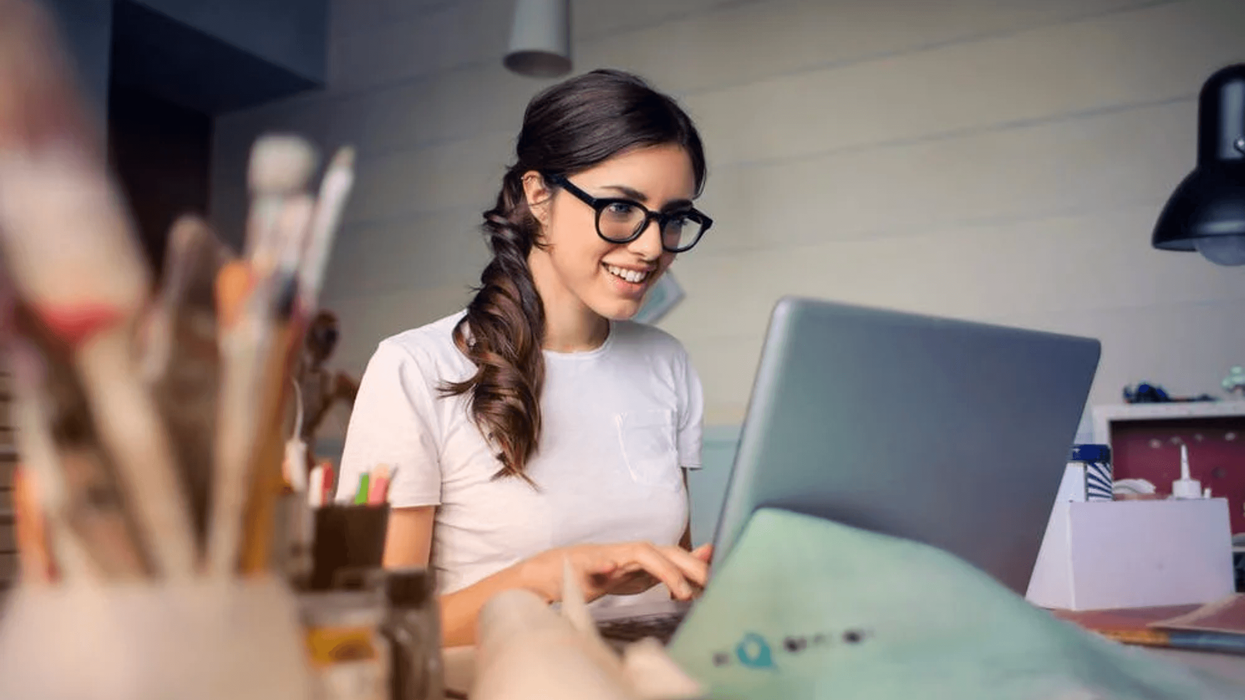 girl on laptop with paintbrushes